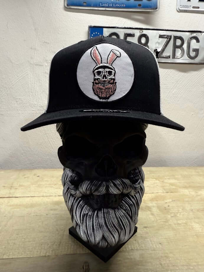 Easter Bunny Beard Guy Trucker Hat on a skull display, featuring skull with beard and bunny ears design.