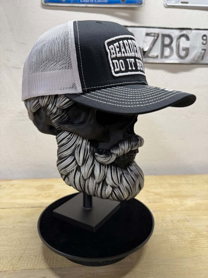 Bearded Guys Do It Better funny trucker hat displayed on a unique skull bust with a beard.