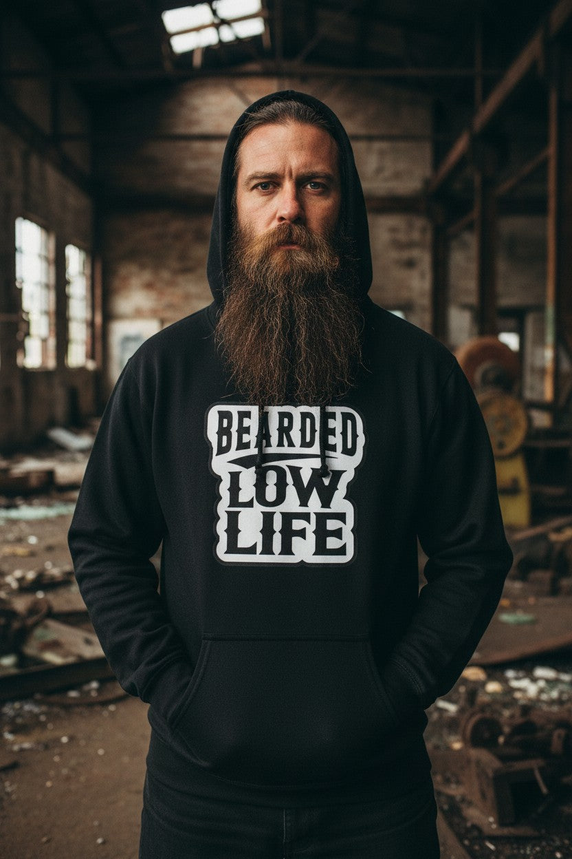 Bearded Low Life hoodie design worn by a man with a long beard in a rustic industrial setting.